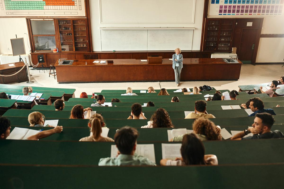 Class at university! Group of students at a college class in a stadium seating layout.